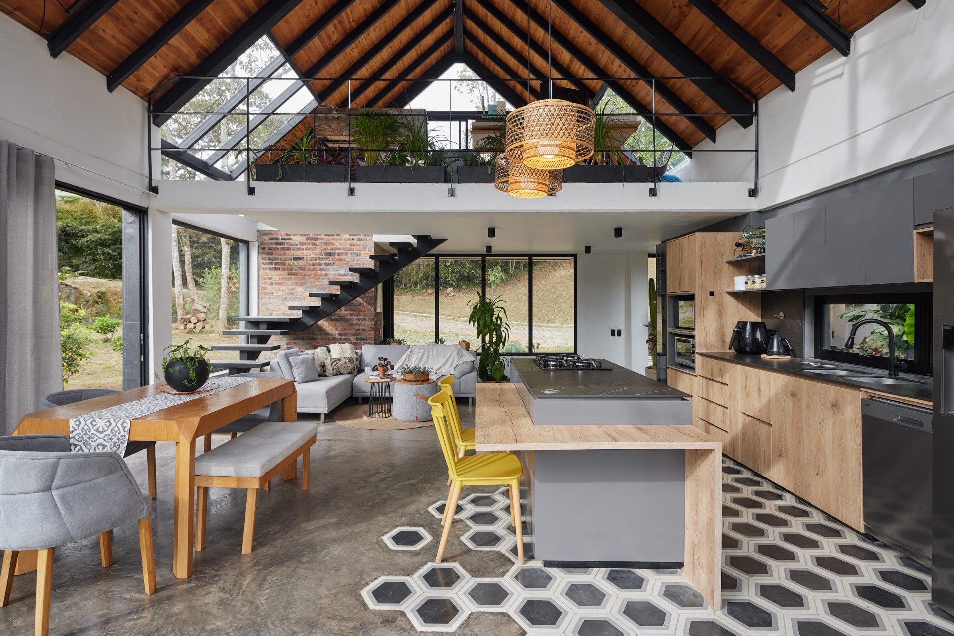 Espacio social de doble altura de Casa Mulata con techo de madera y mezzanina