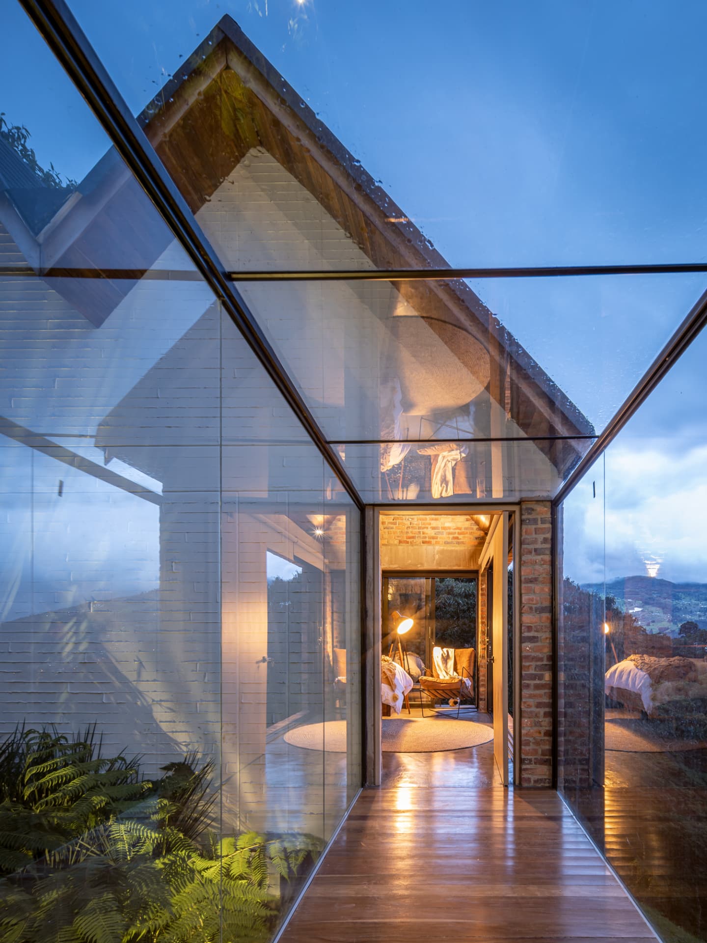 Corredor de vidrio de Up House con piso de madera y vista al interior