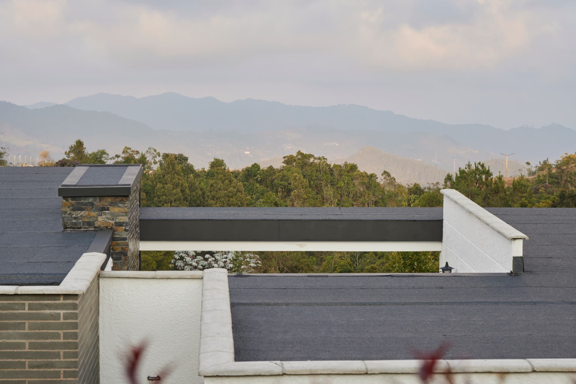 Cubierta de Casa MS con chimenea de piedra y vista a las montañas