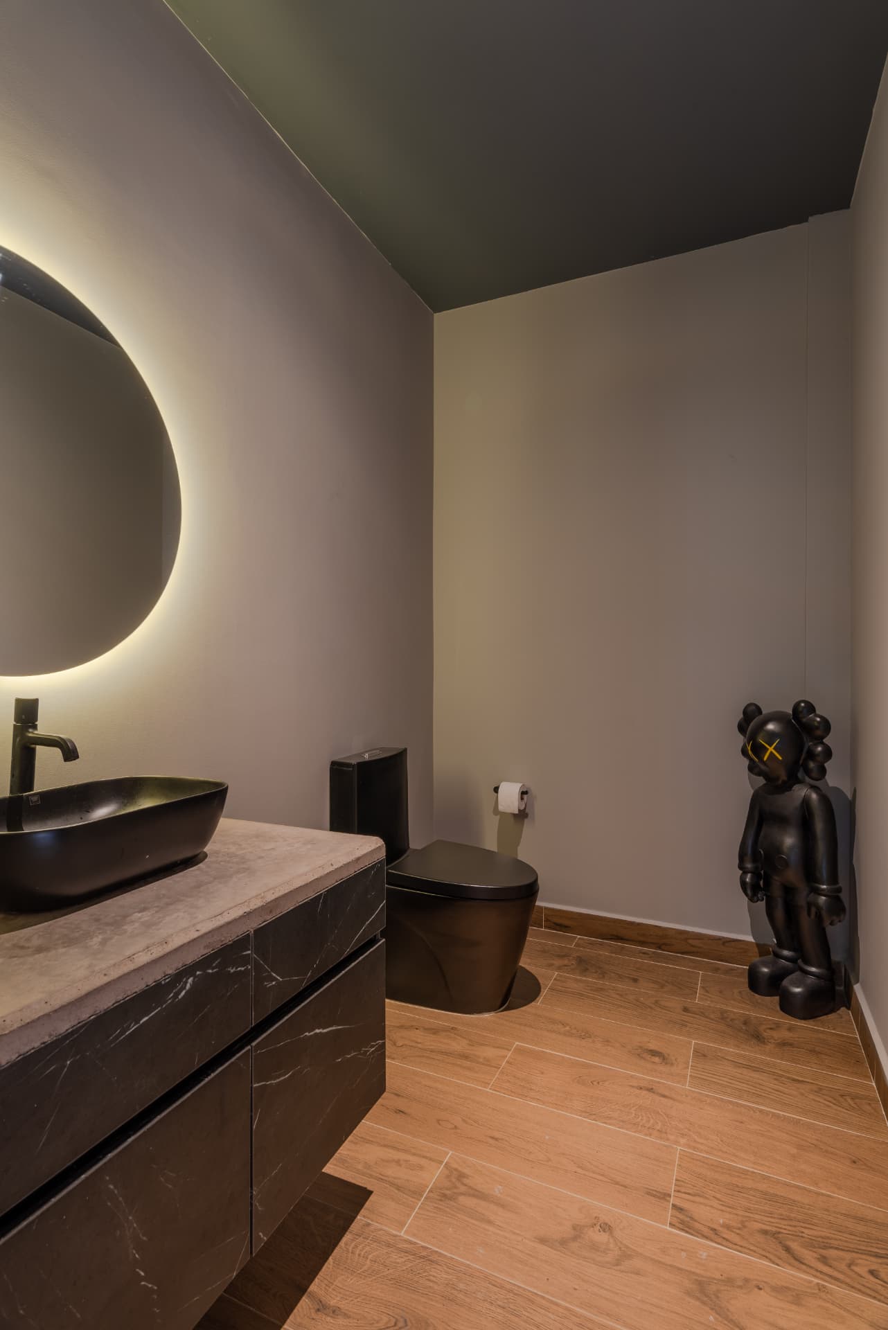 Baño de Pontevedra en tonos oscuros con espejo circular retroiluminado