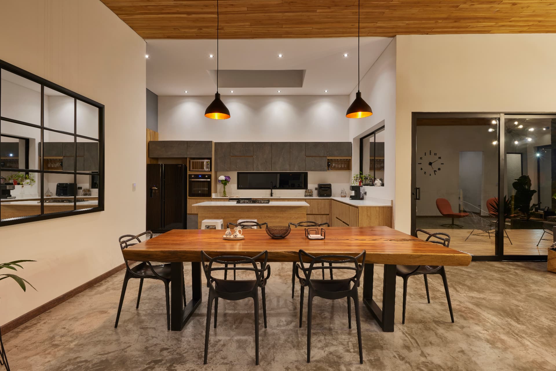 Cocina y comedor de Casa MS con mesa de madera maciza y lámparas colgantes