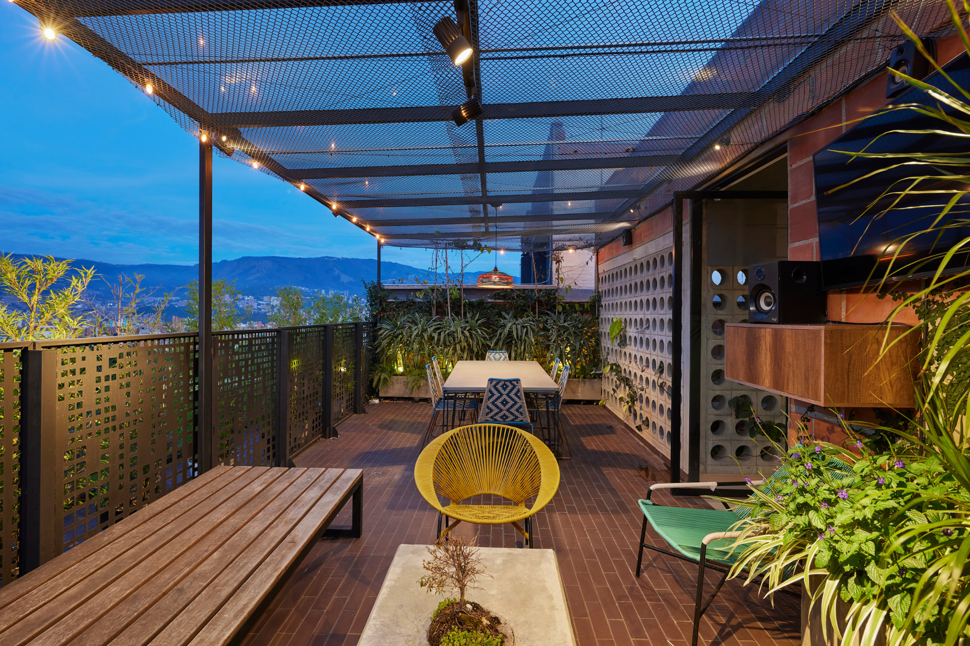 Terraza del Edificio Bianco al atardecer con pérgola metálica y vista a las montañas