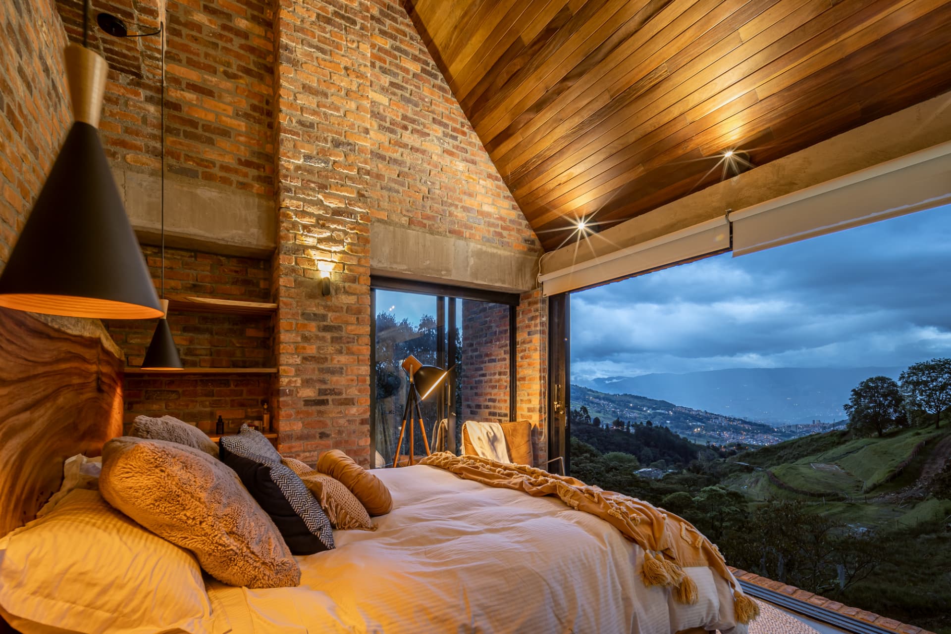 Habitación de Up House al anochecer con techo de madera y vista a las montañas