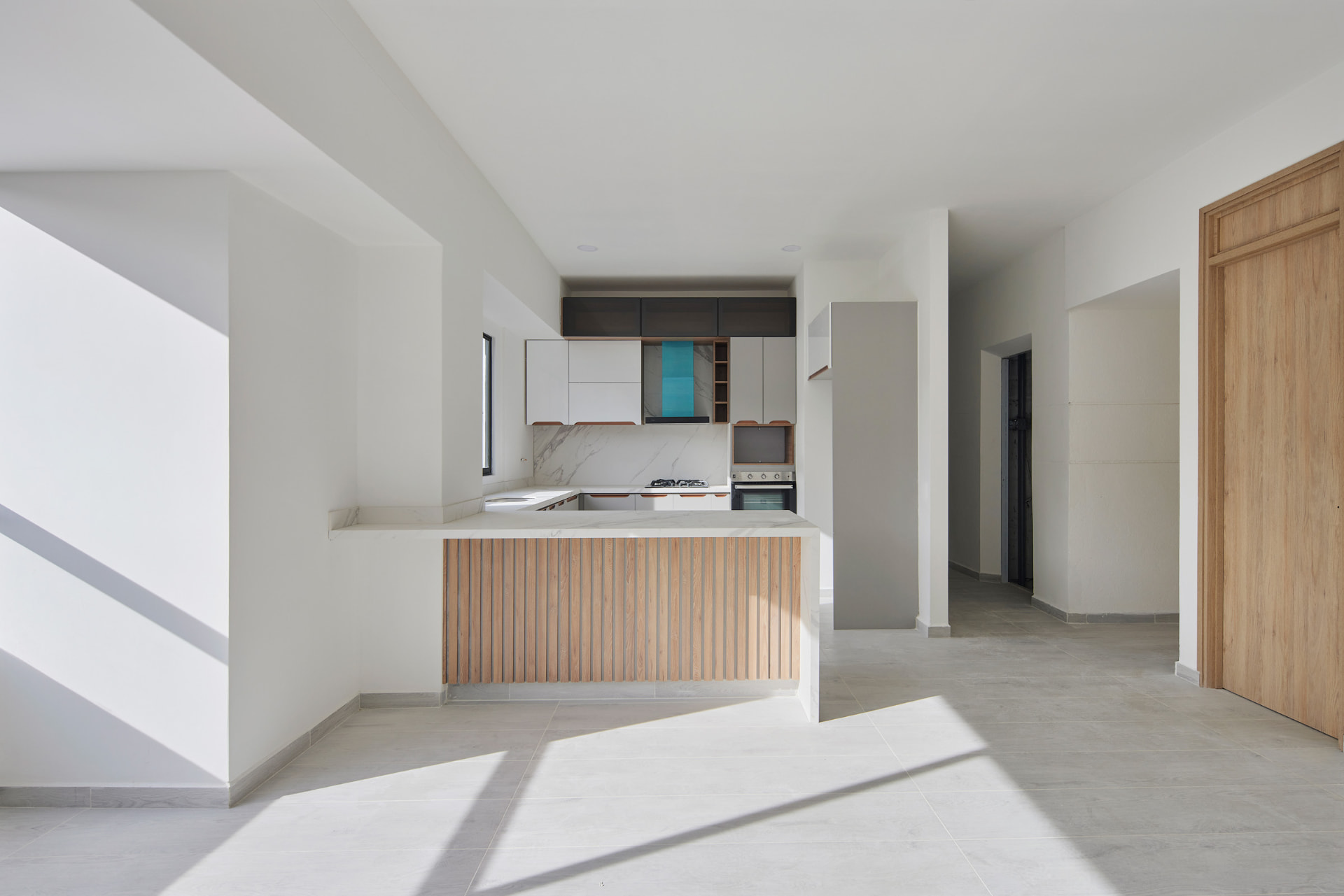 Cocina abierta del Edificio Green Loft con isla de madera y luz natural