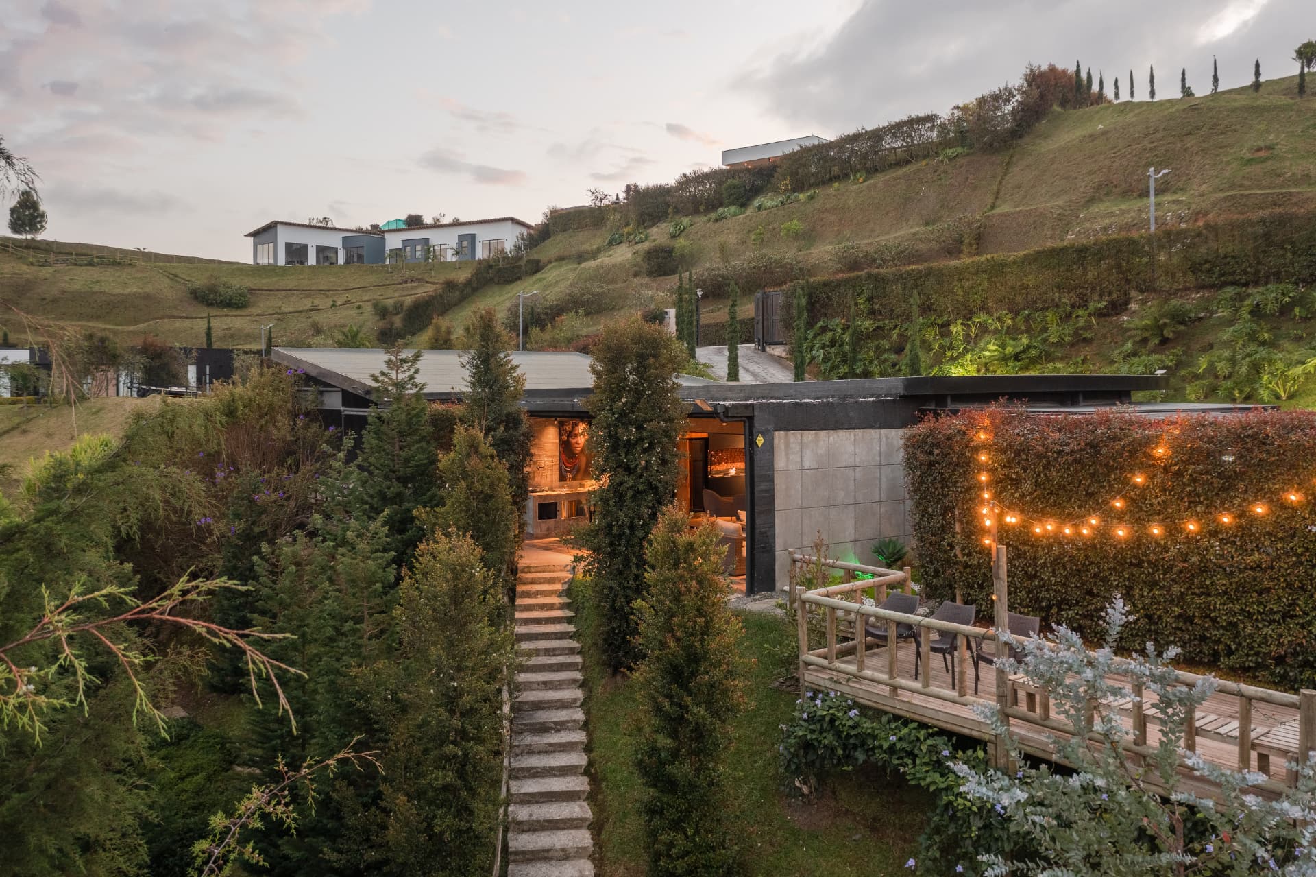 Vista aérea del acceso de Casa Shirley con escalinata entre árboles y terraza iluminada
