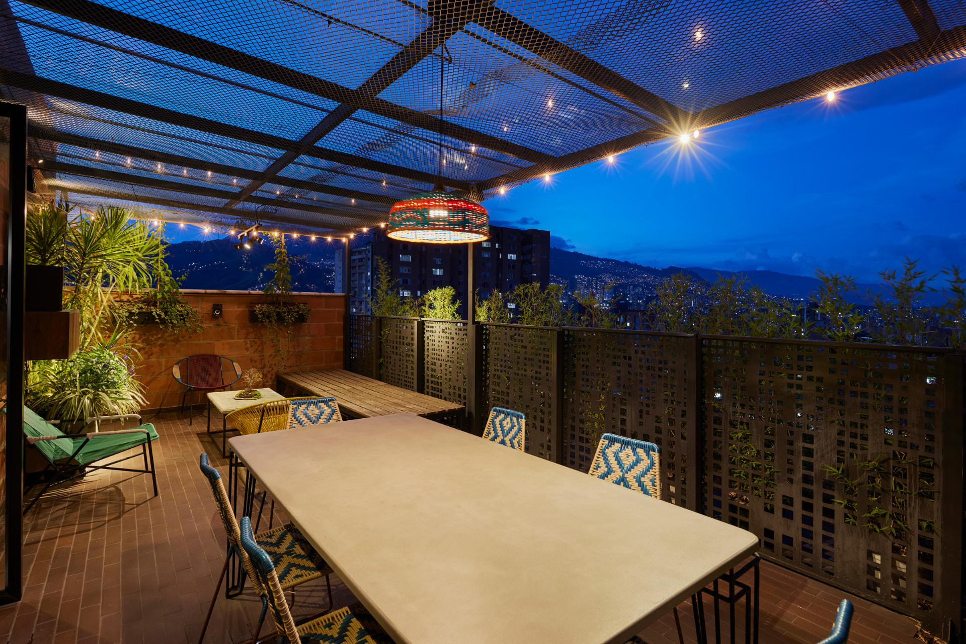 Comedor exterior de la terraza del Edificio Bianco con vista nocturna de la ciudad