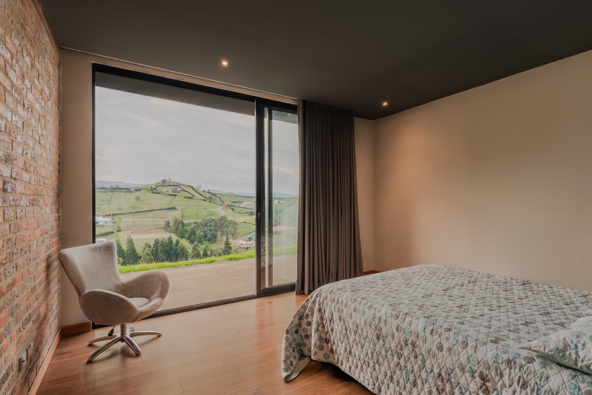 Habitación de Pontevedra con muro de ladrillo y ventanal al valle