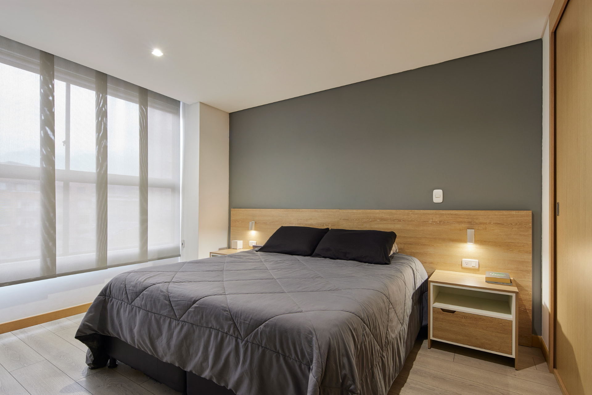 Habitación del Edificio Bianco con cabecero de madera y muro grafito